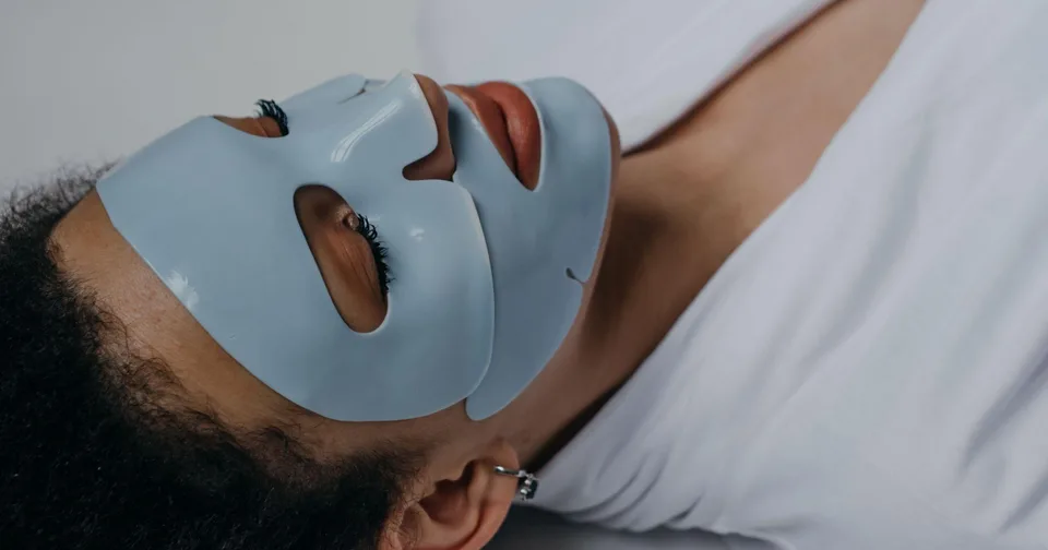 Osoba sa svijetloplavom sheet maskom leži na leđima