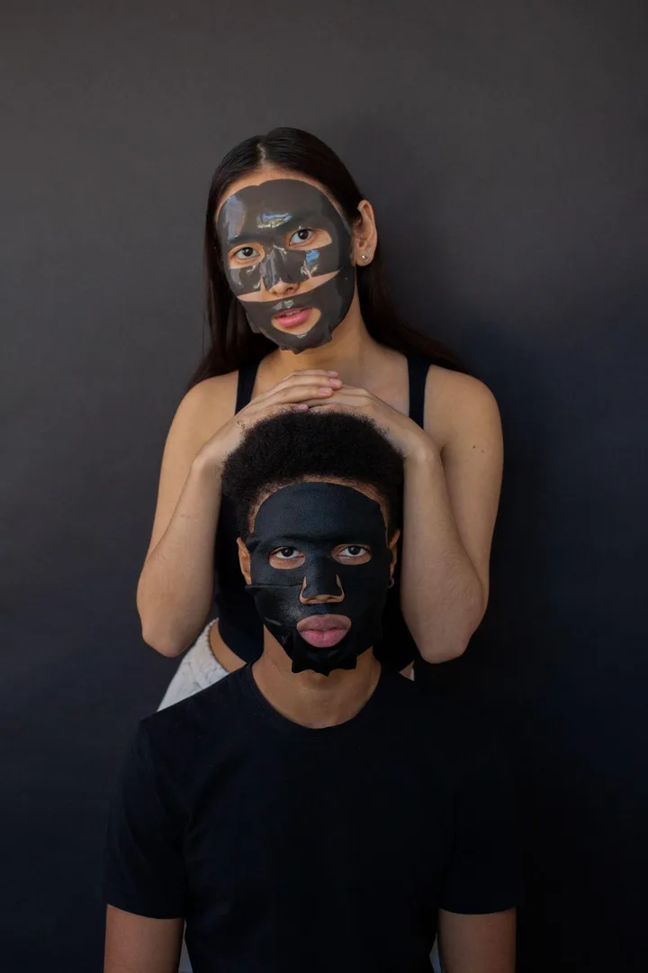 Dvoje ljudi sa sheet maskama na tamnoj pozadini